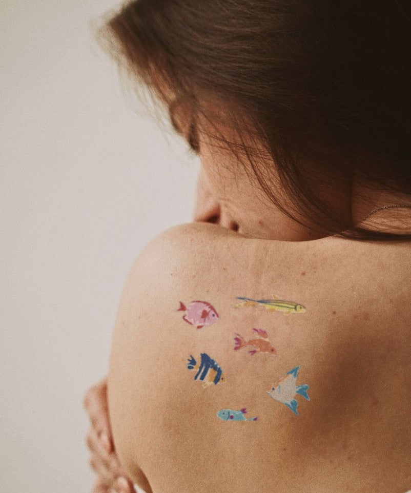 Tropical Fish School hand-drawn temporary tattoo — marine illustration, suited for forearm placement. Waterproof, plant-based, 3–7 day wear. By LastingDays indie artist collective.